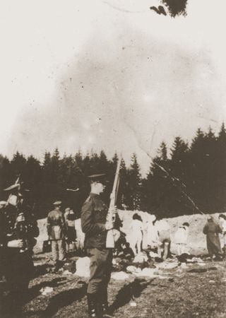 Members of a Lithuanian militia unit force a group of Jewish women from Panevezys to undress before their execution in the Pajuoste Forest